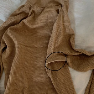 Beige tröja med dragkedja - Säljer en beige tröja från GANT med dragkedja vid halsen. Tröjan har långa ärmar och är tillverkad i ett stickat material. Perfekt för kyligare dagar. Ett hål i armhålan. 