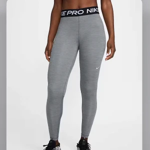 Grå Nike Pro leggings - Säljer ett par grå Nike Pro leggings i storlek XS. De är tillverkade i Dri-FIT-material för att hålla dig torr och bekväm under träning. Nypris 549kr hos Nike. 