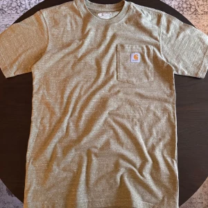 Mörk beige t-shirt från Carhartt - En beige t-shirt från Carhartt. Otroligt bra skick och passar till nästan allt, speciellt nu i vår/sommar. Det är storlek small och är en regular fit på den. Om du har några funderingar är det bara att fråga🙏