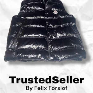 Svart dunväst från Moncler - Snygg svart dunväst från Moncler med glansig finish och dragkedja framtill. Perfekt för att hålla värmen med stil. Västen har en klassisk design med Moncler-logga på bröstet.Från trusted seller vi kommer sicka under 48 timmar på var dagar.