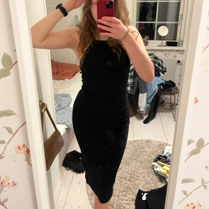 Svart ribbad klänning med öppen rygg - Snygg svart midiklänning med smala axelband och öppen rygg. Klänningen är tight och helt oanvänd. (Kolla gärna in mina andra annonser också)🩷