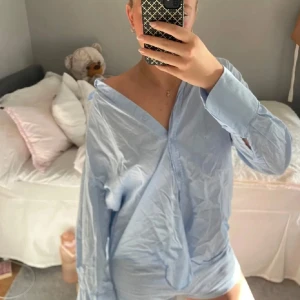 Blå skjorta från Zara - Säljer en ljusblå skjorta med en avslappnad passform. Skjortan har långa ärmar och en klassisk krage. Perfekt för en stilren och bekväm look. Och perfekt nu till våren💗💗