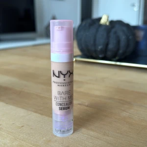 Concealer Serum från NYX - Endast testad, Köpte fel färg. NYX Bare With Me Concealer Serum shade Vanilla. Perfekt för att täcka ojämnheter och ge en naturlig finish. Kommer i en praktisk pumpflaska med rosa lock.
