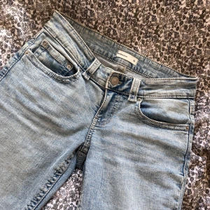 Ljusblå Y2K jeans - Säljer ett par ljusblå jeans med vit söm från Gina tricot i storlek 36. De är knappast använda och är bootcut i benen!