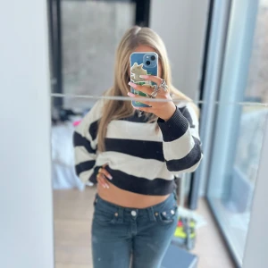 Svartvit randig croppad tröja - Säljer en croppad tröja med breda svarta och vita ränder. Tröjan har lång ärm och är stickad i ett mjukt material. Perfekt för dig som gillar en avslappnad och trendig stil.