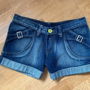 Blå vintage lågmidjade jeansshorts - Säljer ett par jättesnygga jeansshorts som tyvärr inte passade mig. Men förhoppningsvis kan de få ett nytt hem hos dig!🎀