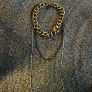 Flerlager halsband från Madly - Säljer ett trendigt halsband i flera lager från Madly. Halsbandet har en tjock guldfärgad kedja och två tunnare kedjor i silver och mörkgrått. Perfekt statement-piece för att lyfta din outfit.