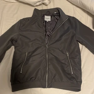 Grå vårjacka från Jack & Jones - Aldrig använd köpte för ca 1 vecka sen o ångrade mig men kunde inte lämna tillbaka  pris går o diskutera