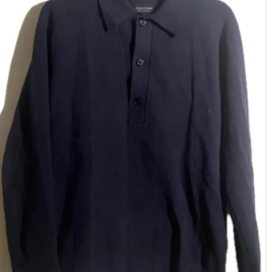 Mörkblå pikétröja från Lexington - Säljer en stilren mörkblå pikétröja från Lexington. Tröjan har långa ärmar och tre knappar framtill. Perfekt för en klassisk och avslappnad look. Den är i nyskick och passar S/M. Skriv vid funderingar!