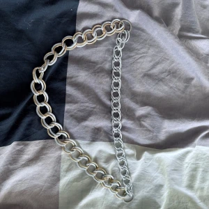 Silvrigt kedjebälte med stora ringar - Säljer ett trendigt bälte i silverfärgad metall med stora, runda länkar. Perfekt accessoar för att lyfta en outfit och ge den en cool touch. Justerbar längd tack vare kedjelänkarna. Passar till både jeans och klänning.