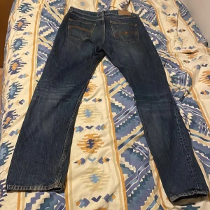 Mörkblå Nudie jeans - Säljer dessa feta mörkblåa nudie jeans då jag ej använt de på ett tag. Finns inga särskilda deffekter förutom det lilla hålet på bild 4, därmed det mer lägre priset. Nypris: Ca 1400kr. Mitt pris: 350kr. Pris kan diskuteras vid snabbt köp. Hör av er om några frågor! 🙌