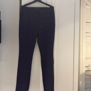 Marinblå kostymbyxor från ICHI - Säljer ett par klassiska marimblå kostymbyxor från ICHI i storlek 40. Byxorna har normal passform, raka ben, mid waist och stängs med dragkedja och hake. Perfekta till en stilren look och enkla att matcha med olika toppar. Hör av er vid intresse!💕Aldrig använda!