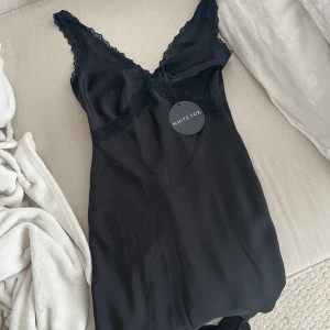 Svart kort satin klänning från White Fox - Svart kort satin klänning från Whitefox med smala axelband i storlek s. Använd 1 gång 🤍