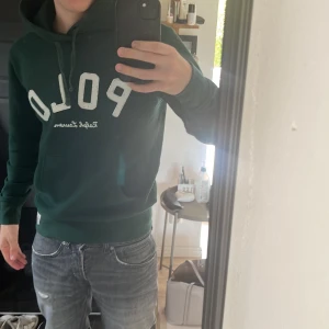 Mörkgrön hoodie från Polo Ralph Lauren - Säljer en mörkgrön hoodie från Polo Ralph Lauren med stor vit POLO-text på bröstet. Köpt för runt 2500 på zalando. Nästan som ny sparsamt använd