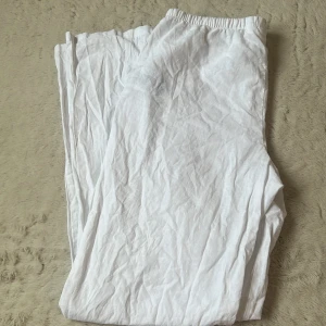 Vita linnebyxor från Gina Tricot - Vita, luftiga linnebyxor från Gina Tricot med resår och snörning i midjan. Perfekta för varma dagar och har en avslappnad passform. Byxorna är raka i modellen och tillverkade i ett svalt linnematerial. Helt oanvända💞