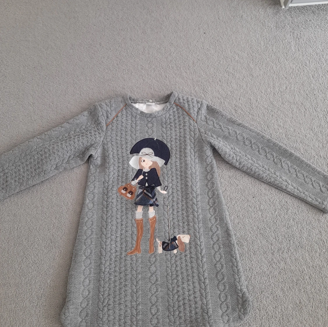 Grå stickad klänning med broderad figur