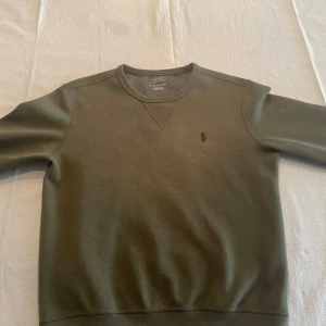 Olivgrön tröja från Ralph Lauren - Säljer en stilren olivgrön tröja från Ralph Lauren. Säljer eftersom jag köpte en för liten storlek. Mycket bra skick!
