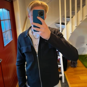 Svart tröja/sweatshirt från jack&andjones - Säljer en stilren svart jacka från Jack & Jones med dragkedja framtill. Jackan har två bröstfickor. Jackan kan man både ha som en tröja under jackan men även som en jacka. :nypris: 899
