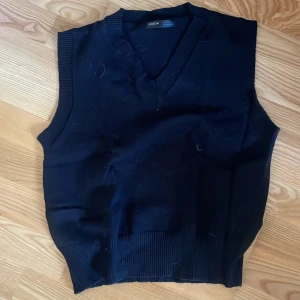 Svart stickad väst från Shein - Snygg svart stickad väst från Shein med v-ringning och ribbade kanter. Perfekt för lager-på-lager-stil och passar till många olika outfits.