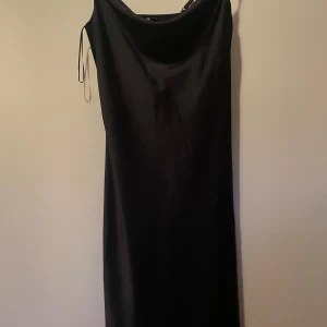 Svart klänning från Pieces - Jättefin svart klänning från Pieces i glansigt tyg. Klänningen har smala axelband och en enkel, stilren design som går ner till vaderna. Den passar perfekt för festliga tillfällen eller sommarkvällar med en kofta över. Den har används ett fåtal gånger då den är lite stor runt bysten på mig, så den är i princip nyskick. Det är storlek XS men den är stor i storleken och passar även mig som är M/L❤️ pris går att diskutera