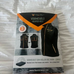 Svart värmeväst från Haunter - Säljer en svart värmeväst från Haunter med tre värmeelement, två över bröstet och ett på ryggen. Västen har dragkedja och drivs av en powerbank (ingår ej). Perfekt för att hålla sig varm under kalla dagar.