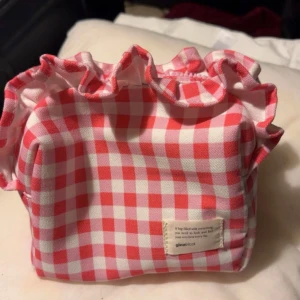 Rutig necessär från Gina Tricot - Säljer en söt rutig necessär från Gina Tricot i rött och vitt. Perfekt för att förvara smink. 