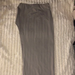 Beige långkjol - Snygg beige långkjol i ett mjukt och följsamt material. Perfekt för en stilren look. Kjolen har en enkel design utan mönster eller detaljer, vilket gör den lätt att matcha med olika toppar.