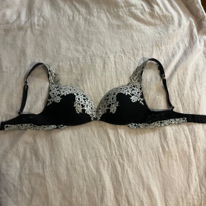 Svart spetsbehå från intimissimi🖤 - Elegant svart behå med vacker vit spetsdetaljering. Justerbara axelband och hakknäppning bak för perfekt passform. Endast använd någon enstaka gång, är som i nyskick. 