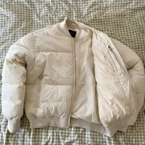 Pufferjacka från H&M | L - Säljer min vita pufferjacka från H&M. Knappt använd.   Storlek L