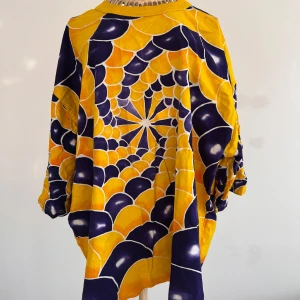 Färgglad,  psykedelisk t-shirt från 90-talet - Säljer en unik och färgglad T-shirt med ett psykedeliskt mönster i gult och mörkblått. T-shirten har en lös passform. Fläck på ena axeln, se sista fotot. Den har deltagit på flertalet ravefester på det glada 90-talet. Tillverkad i 100% rayon för en lätt och bekväm känsla. Passar M/L