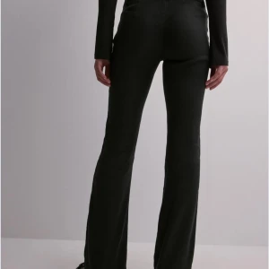 Svarta linnebyxor med bootcut - Snygga svarta linnebyxor med bootcut-stil. De är lågmidjade och har en elegant passform som framhäver figuren. Perfekta för en stilren look. Endast använda ett fåtal gånger. Säljer pga passar inte min kroppstyp.