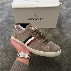 Moncler Skor - .Säljer dessa sjukt feta Moncler skor i storlek 42! Beige färg med schysta moncler detaljer, perfekt för vår/sommar! Skick 9/10. Dustbag, kort och kvitto ingår, ej box! Pris kan alltid diskuteras, först till kvarn!🌟🏆🍾