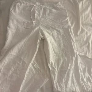 Vita linnebyxor med låg midja - Snygga och bekväma vita linnebyxor med dragsko i midjan. Perfekta för en avslappnad stil. Byxorna har en loose passform och är tillverkade i ett lätt och luftigt material. Lågmidjade i storlek 170 från Gina Young men passar xs/s😍
