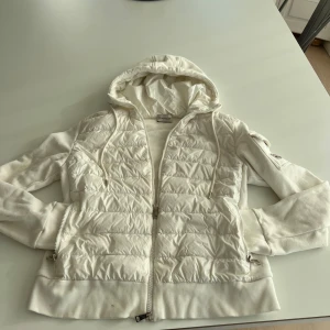 Vit Moncler cardigan - Säljer ni min skit snygga vita Moncler cardigan helt nytvättad på kemtvätt, inga skador alls eller defekter förutom någon liten fläck nere bredvid dragkedjan, se i bilden. Annars en skit bra och snygg jacka till hösten, våren eller sommarkvällar. Den är alltid bra och inte för varm eller för kall. Skriv gärna vid frågor eller funderingar 