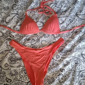 Coral bikini med knytband - Orange bikini med trekantsöverdel och knytband i nacken och ryggen. Endast andvänd vid ett tillfälle. 