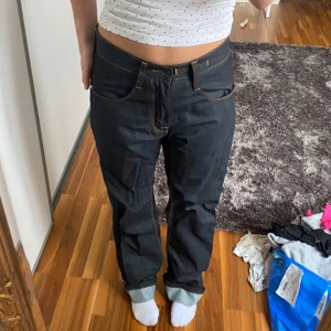 Lågmidjade baggy jeans med broderad detalj - Snygga svarta baggy jeans med en unik broderad detalj i vitt på bakfickorna. Byxorna har en klassisk femficksdesign och kontrasterande sömmar. De är baggy och Lågmidjade❤️