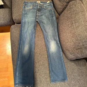 Blå Levi's jeans 501 - Snygga blå jeans från Levi's med klassisk femficksdesign och en straight passform. De har en traditionell dragkedja och knappstängning. Perfekta för en avslappnad stil. Pris går att diskutera!