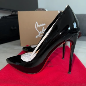 Svarta lackpumps från Christian Louboutin - Säljer ett par ikoniska svarta pumps i lack från Christian Louboutin med klassisk röd sula och spetsig tå. Skorna har hög klack och elegant form, perfekta för att lyfta vilken outfit som helst. Dem är 12cm och är so kate modellen. Dem är använda en gång men eftersom dem passade inte riktigt. 
