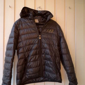 Svart pufferjacka från Emporio Armani EA7 - En snygg Armani jacka perfekt nu när de börjar bli lite varmare då den är tunn. Jackan är i bra skick och äkta. Hör av er vid frågor💯