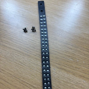 Svart läderarmband med nitar och svarta örhängen - Säljer ett svart läderarmband med silvriga nitar och ett par svarta örhängen i form av små kors. Armbandet har två hål för justering och ger en cool rockig vibe. Perfekt accessoar för att lyfta din outfit.