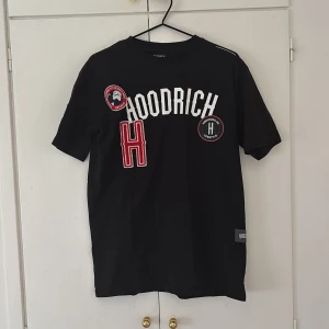 Svart t-shirt från Hoodrich  - Svart t-shirt från Hoodrich med tryckdetaljer framtill. Klassisk passform med rund halsringning och korta ärmar. Den är använd ca 3 gånger men har inga defekter alls.