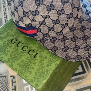 Gucci keps med monogram - Snygg keps från Gucci med klassiskt GG-monogram i blått på beige botten. Kepsen har en röd och blå rand på sidan och är tillverkad i ett tåligt tygmaterial. Perfekt accessoar för att lyfta din stil. Äkta sällsynt 