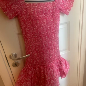 Rosa mönstrad klänning med volang - Supersöt rosa klänning ifrån hm, aldrig använd 