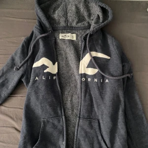 Mörkblå hoodie från Hollister - Hollister kofta i mörkblå. Dragkedjan är lite trasig därav priset 