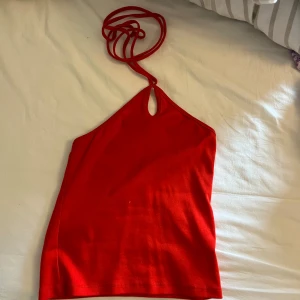 Röd halterneck topp från BikBok - Säljer denna toppen från BikBok då den inte kommer till användning. Finns inte kvar på hemsidan. Endast använd en gång och i nyskick🥰 