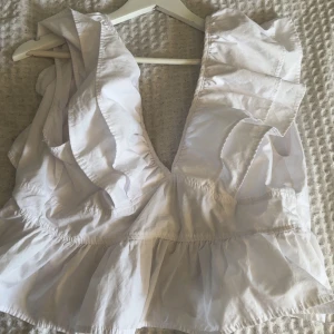 Vit volangtopp - Säljer en vit topp med volangdetaljer, såååå fin! Perfekt nu till sommaren😍. Står att den är XL men det stämmer inte alls då jag brukar ha M/L inte kan ha den. Skulle säga s eller xs 