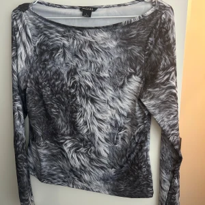 Grå långärmad topp med pälsmönster från Monki - Långärmad topp från Monki med grått och svart pälsliknande mönster. Tunn och stretchig. Rund halsringning och figurnära passform.