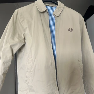 Beige jacka från Fred Perry - Säljer en helt ny stilren beige jacka från Fred Perry med klassisk broderad logga på bröstet. Nypris 3000. Priset kan diskuteras🙌