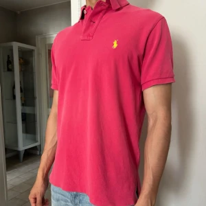 Polo Ralph Lauren Piké - Rosa, i fint skick - !!Priset är stående!!  Skick: Använd men i mycket fint skick - inga fläckar, noppor eller slitningar // Stolek: M - normal i storlek // Passform: Slim-fit // Färg: Rosa - en elegant dov rosa som passar både vardag och fest // Material: 100% bomull i luftig mesh - mjuk, sval och hållbar // Detaljer: Ribbad krage, tvåknappsplacket // Leverans: Postas inom 24 timmar efter du köpt - alltid med spårbar rakt // Kontakt: Har du frågor eller vill ha fler bilder? Tveka inte att höra av dig!