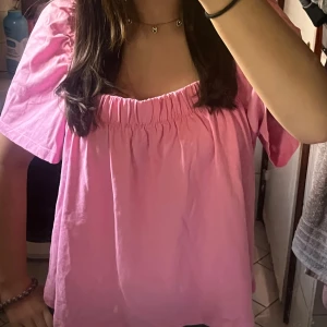 Rosa  blus - Säljer en söt rosa blus med korta ärmar och rynkad resår vid halsringningen. Toppen har en luftig passform och öppen rygg, perfekt för varmare dagar❤️